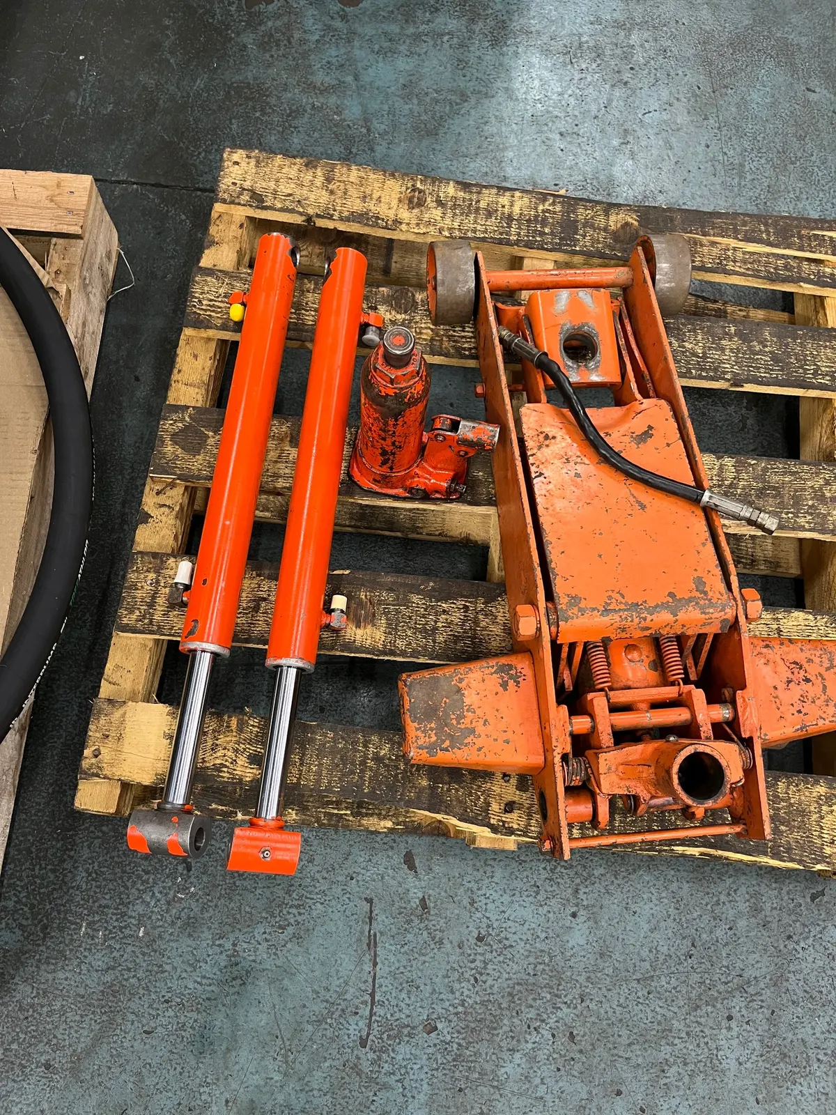 Orange hydraulic cylinders and motor on pallet