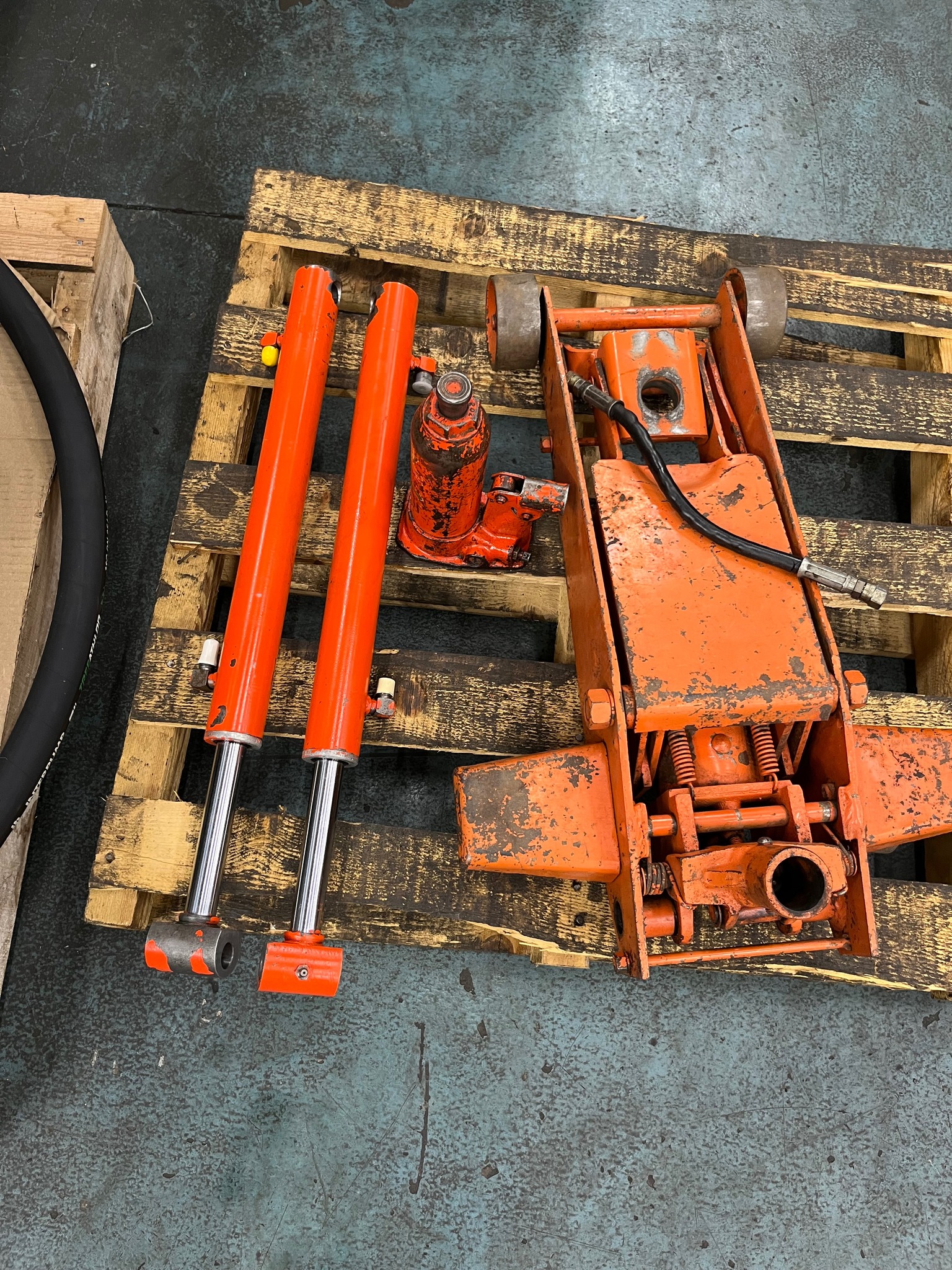 Orange hydraulic cylinders and motor on pallet